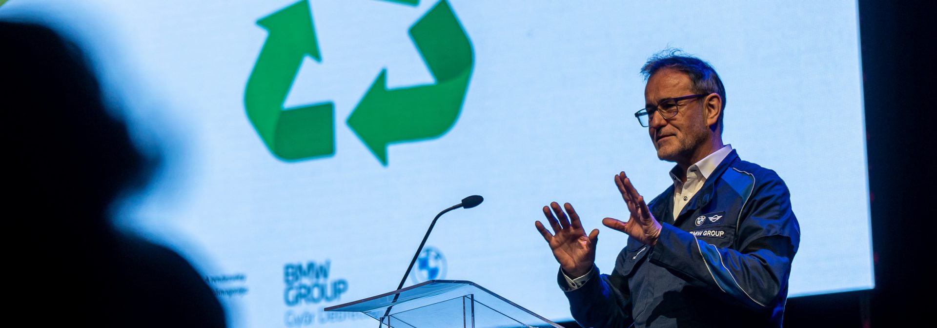 Man is standing in front of a projection on the wall and talks about the environment.