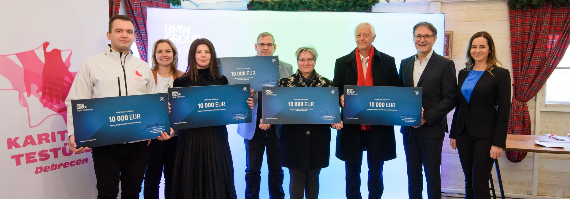 A group of people is posing with the donation checks