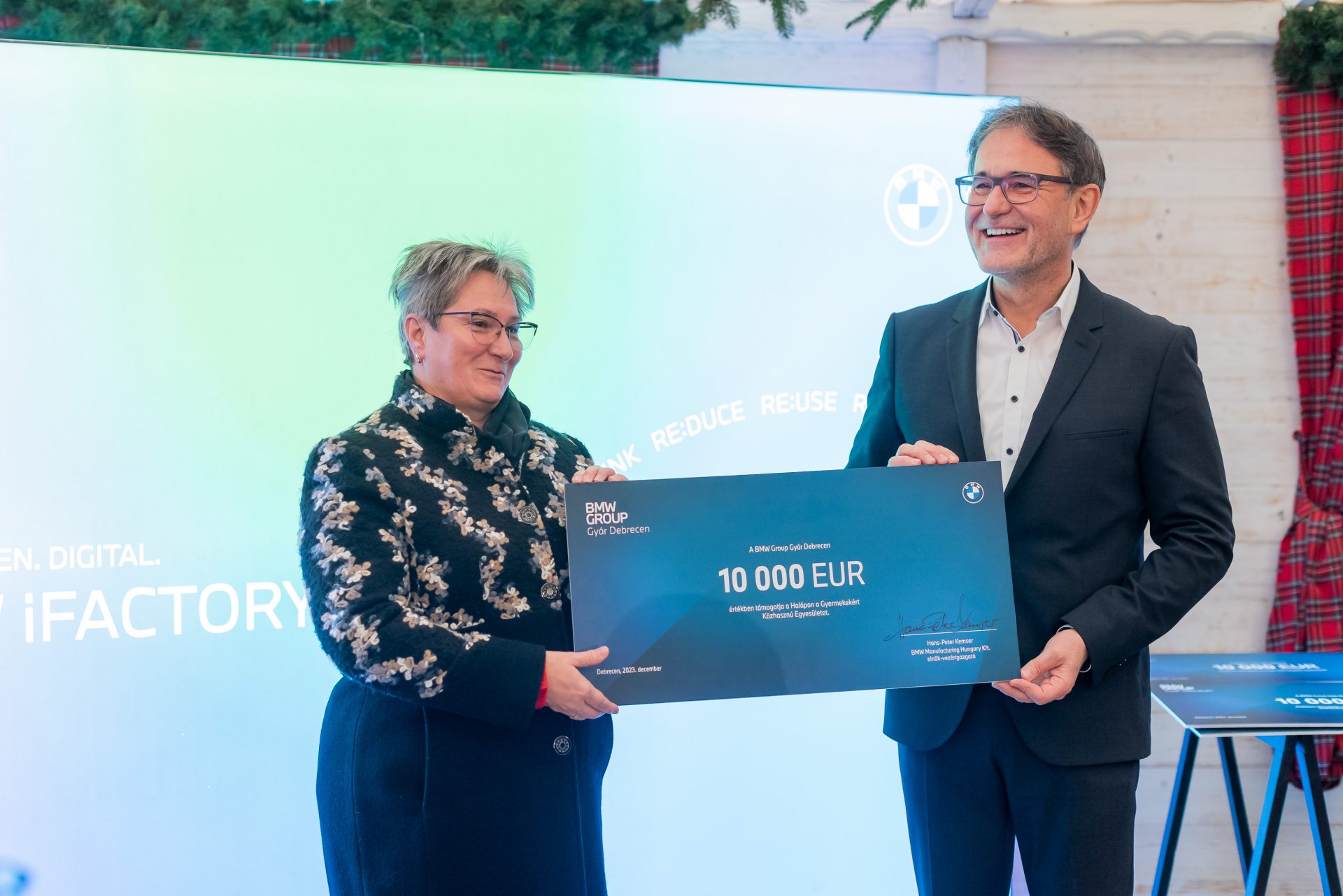 A man and a woman are holding up a donation check together