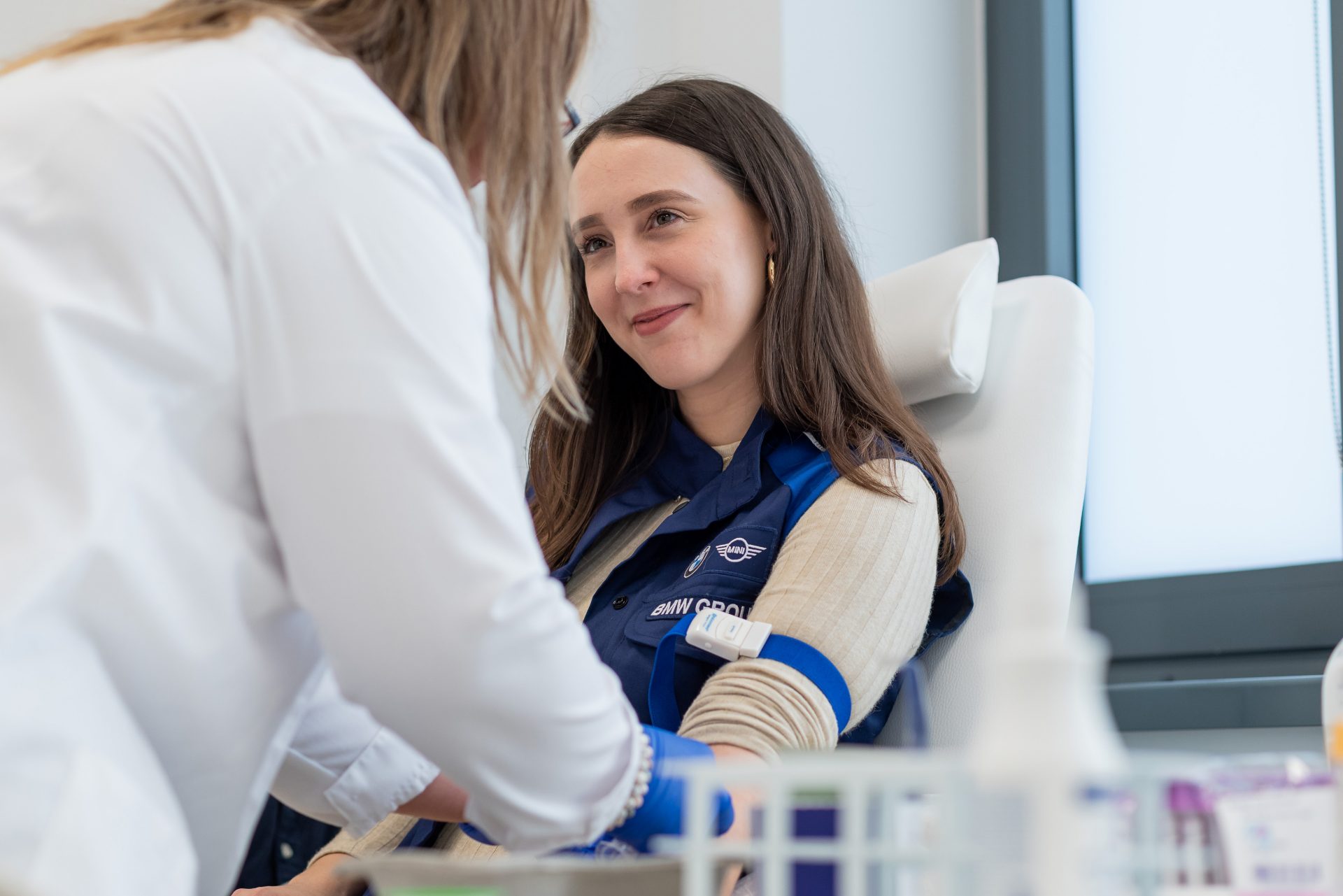 An employee is taking blood from a patient