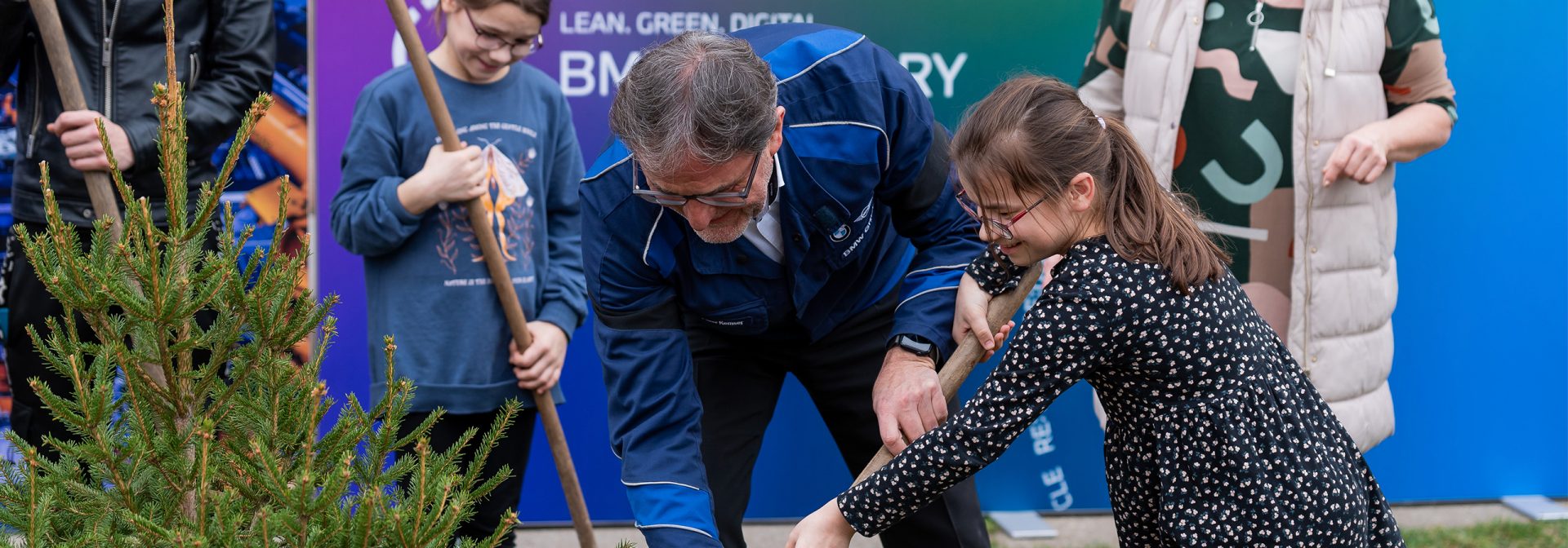 A man and a girl are planting a tree together