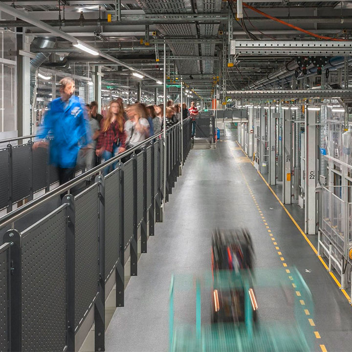 Innenansicht des BMW Werks München mit einer geführten Tour im Hintergrund