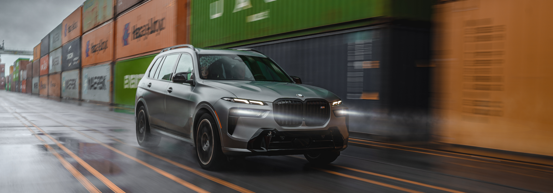 X7 at inland port drving through line of shipping containers 