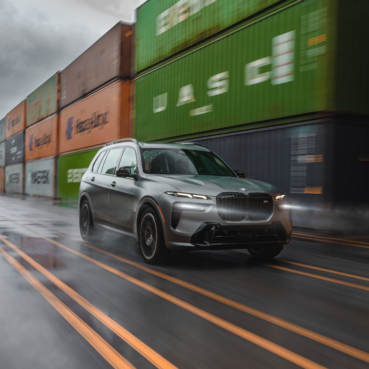 X7 at inland port drving through line of shipping containers. 