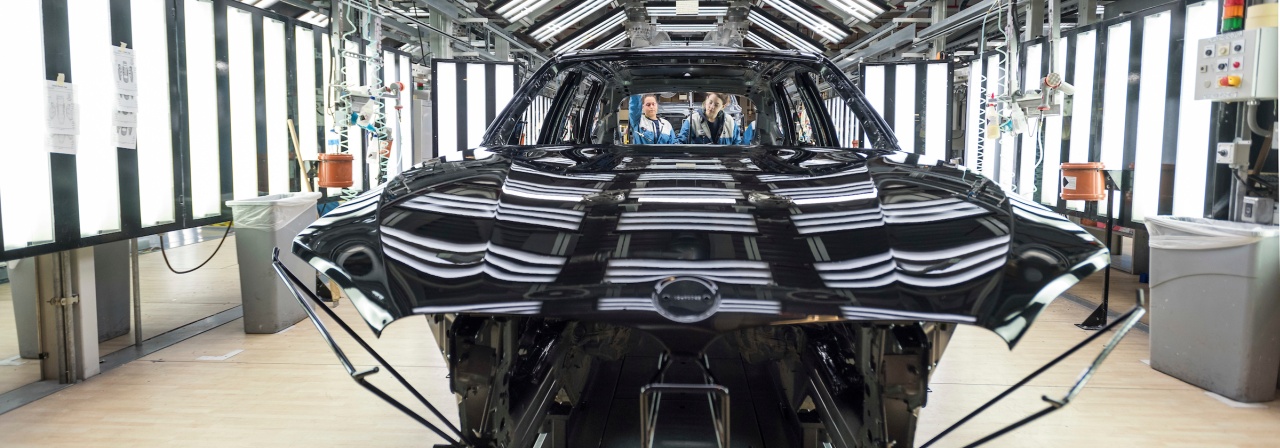 BMW vehicle being inspected in paint shop process area. 