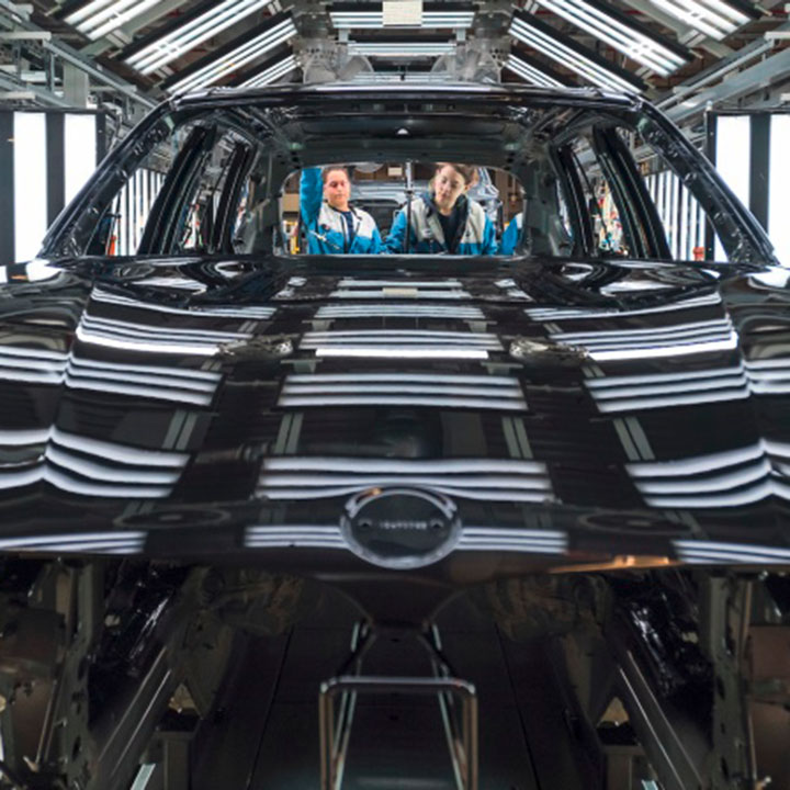 BMW vehicle being inspected in paint shop process area. 