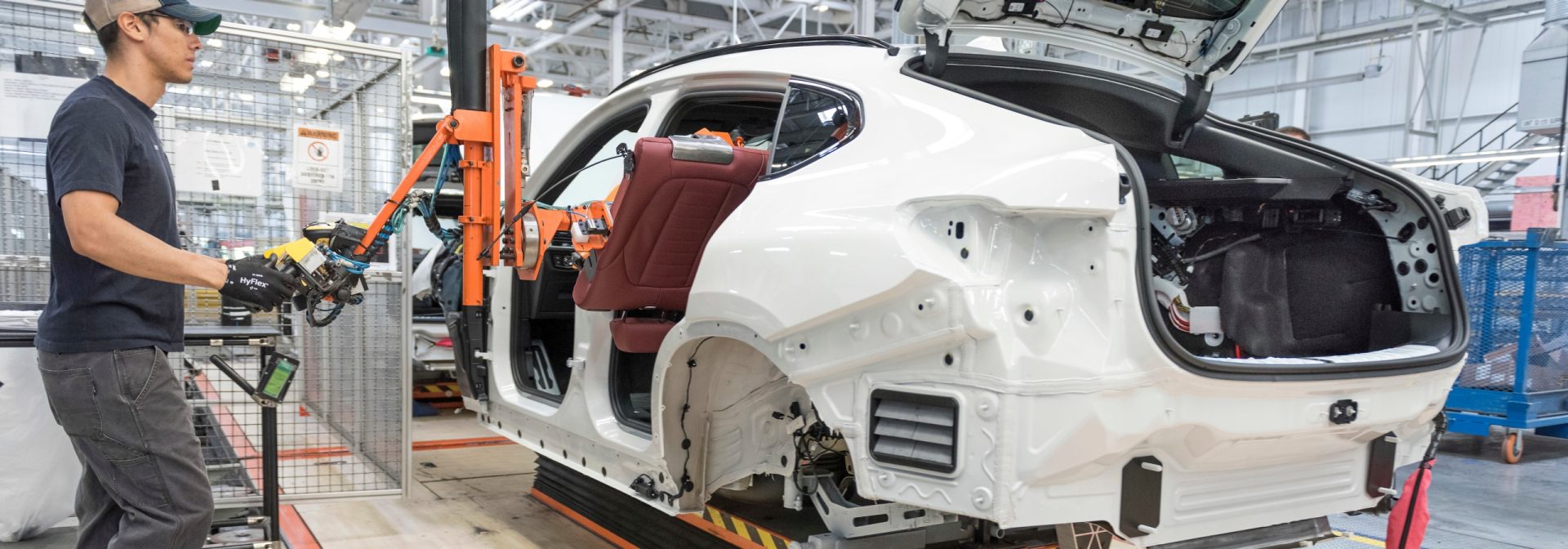 Assembly associate using lift assist to install  a back seat into the vehicle. 