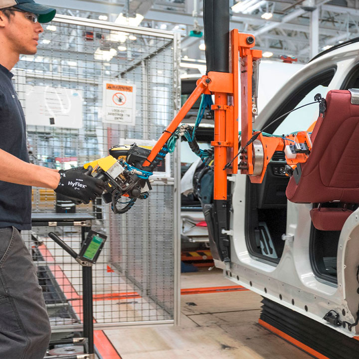 Assembly associate using lift assist to install  a back seat into the vehicle. 