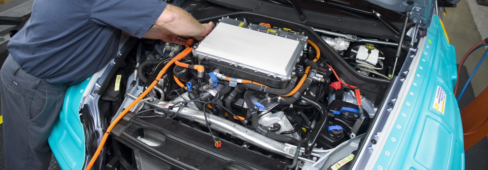 Associate working on the assembly of a BMW X6 Active Hybrid.