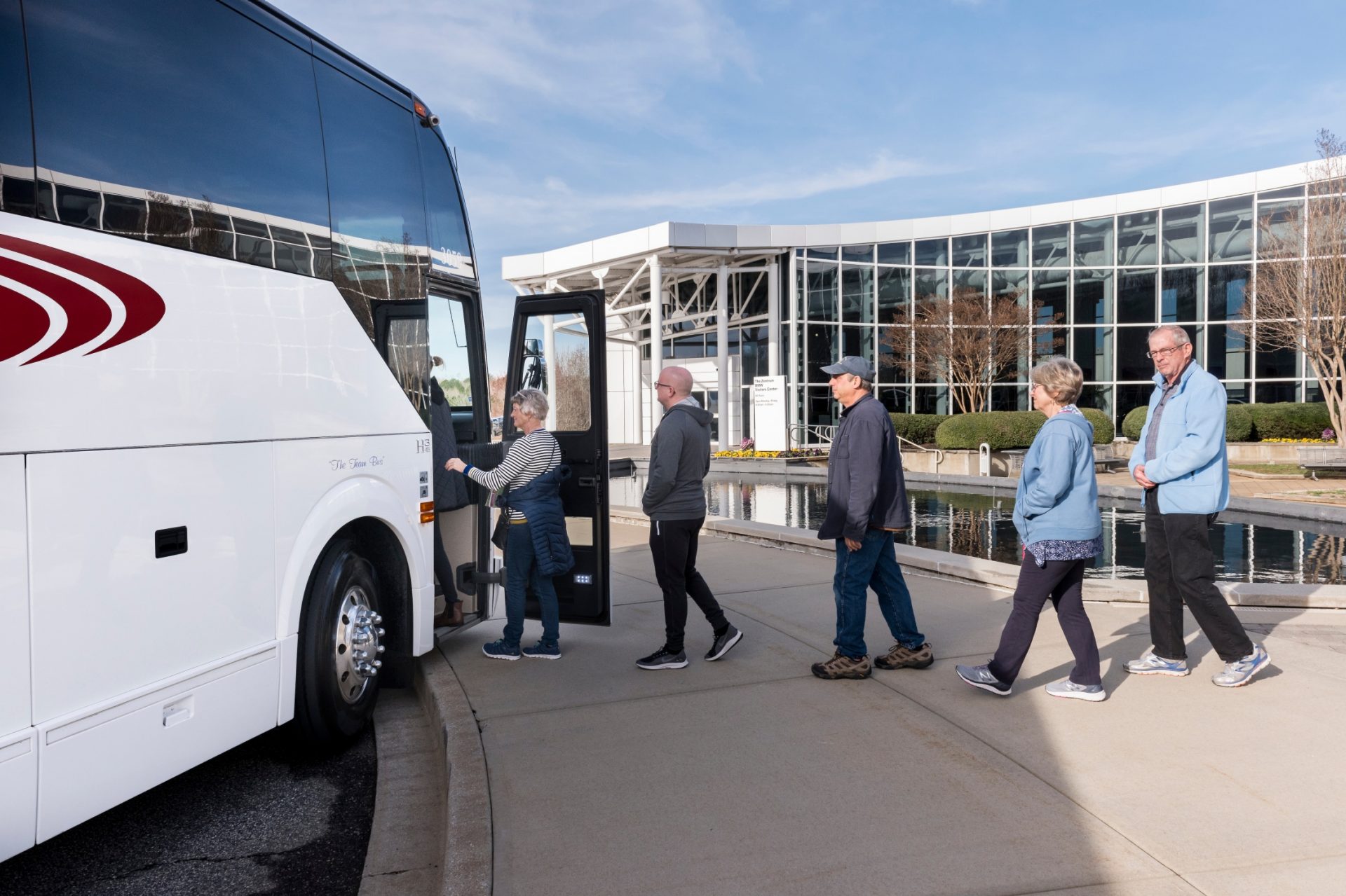 Tour Guests lined up to load coach bus. 