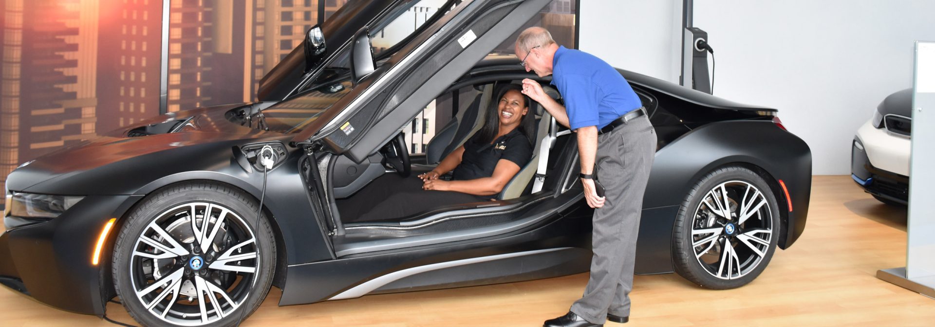 Teacher and student enjoy experiencing a BMW i8 on the platform in the Zentrum Museum.