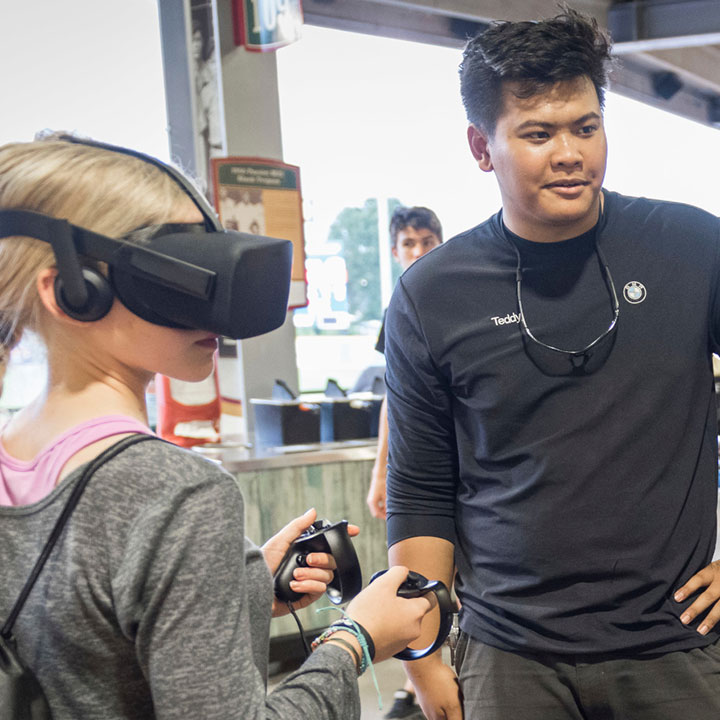 BMW Associate assists a young girl as she experiences a virtual reality demo at the South Carolina Advanced Manufacturing and Engineering Night.  