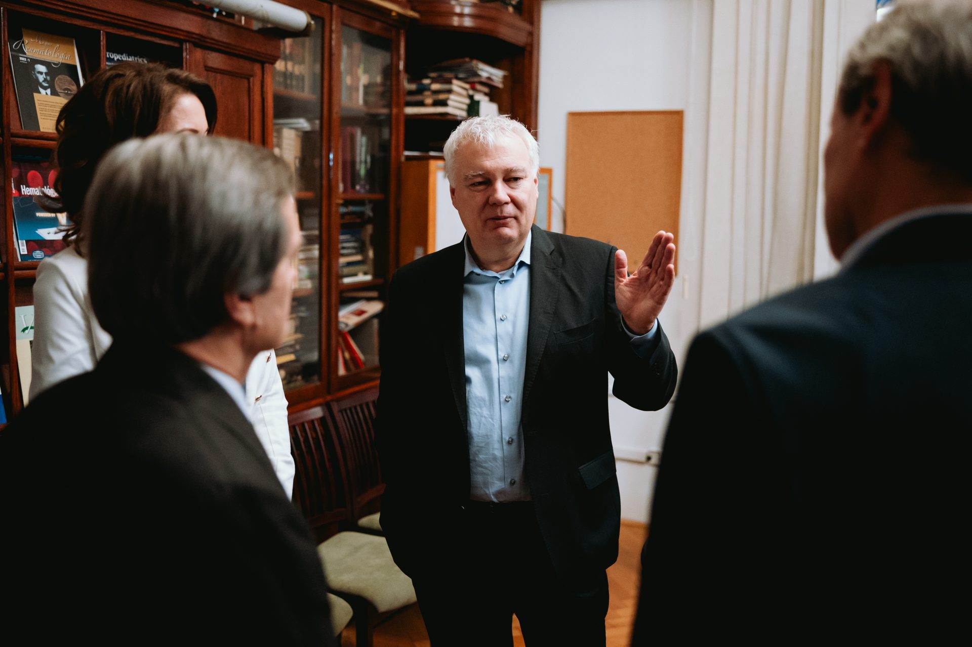 an elderly man is talking to three people