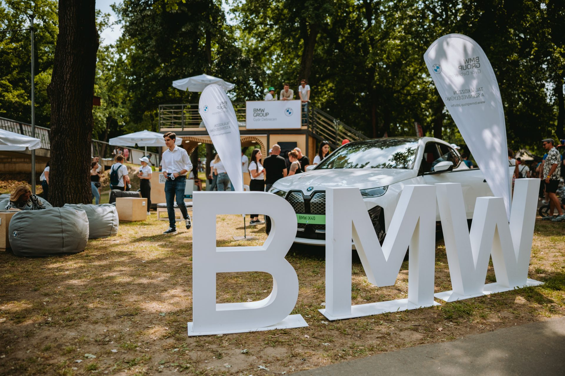 BMW letters standing in front of a car