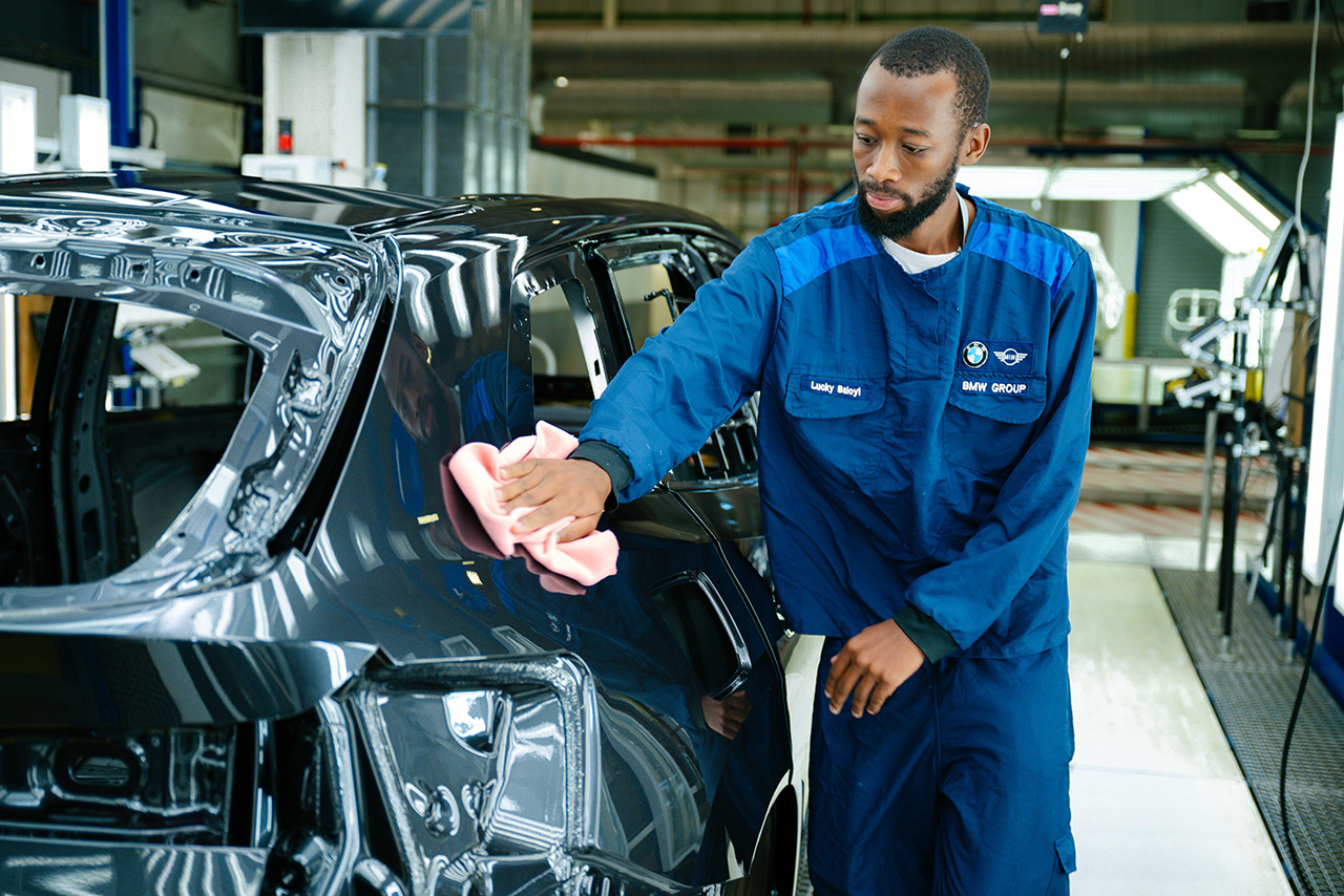 Two women are engaged in planting plants in a garden, using shovels and surrounded by fresh soil and greenery.