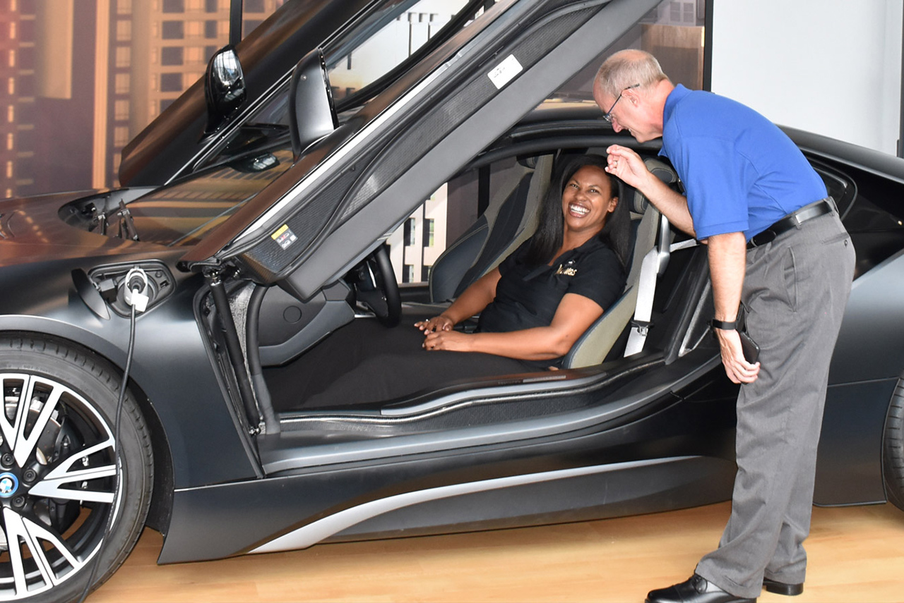 Teacher and student enjoy experiencing a BMW i8 on the platform in the Zentrum Museum.