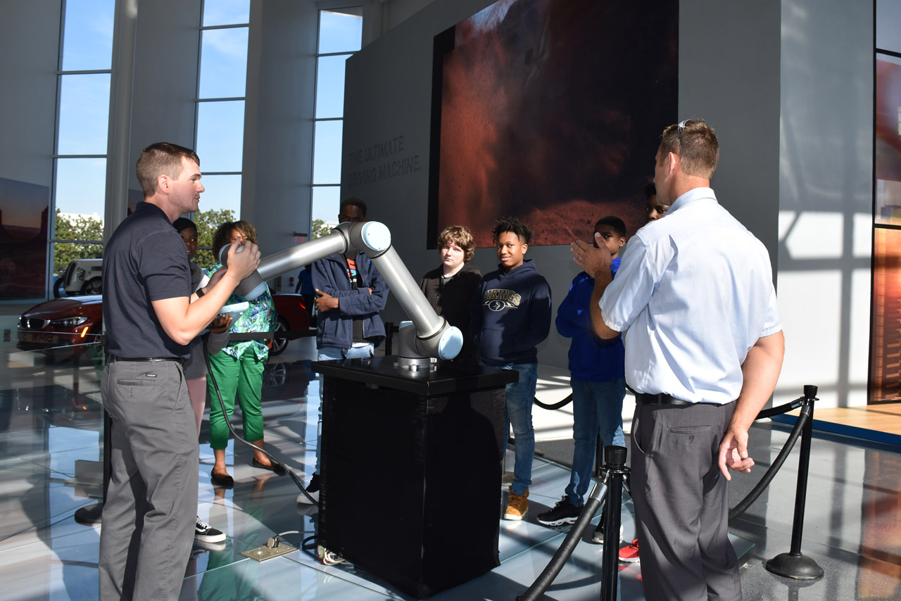 BMW Associates give an interactive robotics and advanced manufacturing demonstration to a group of students. 