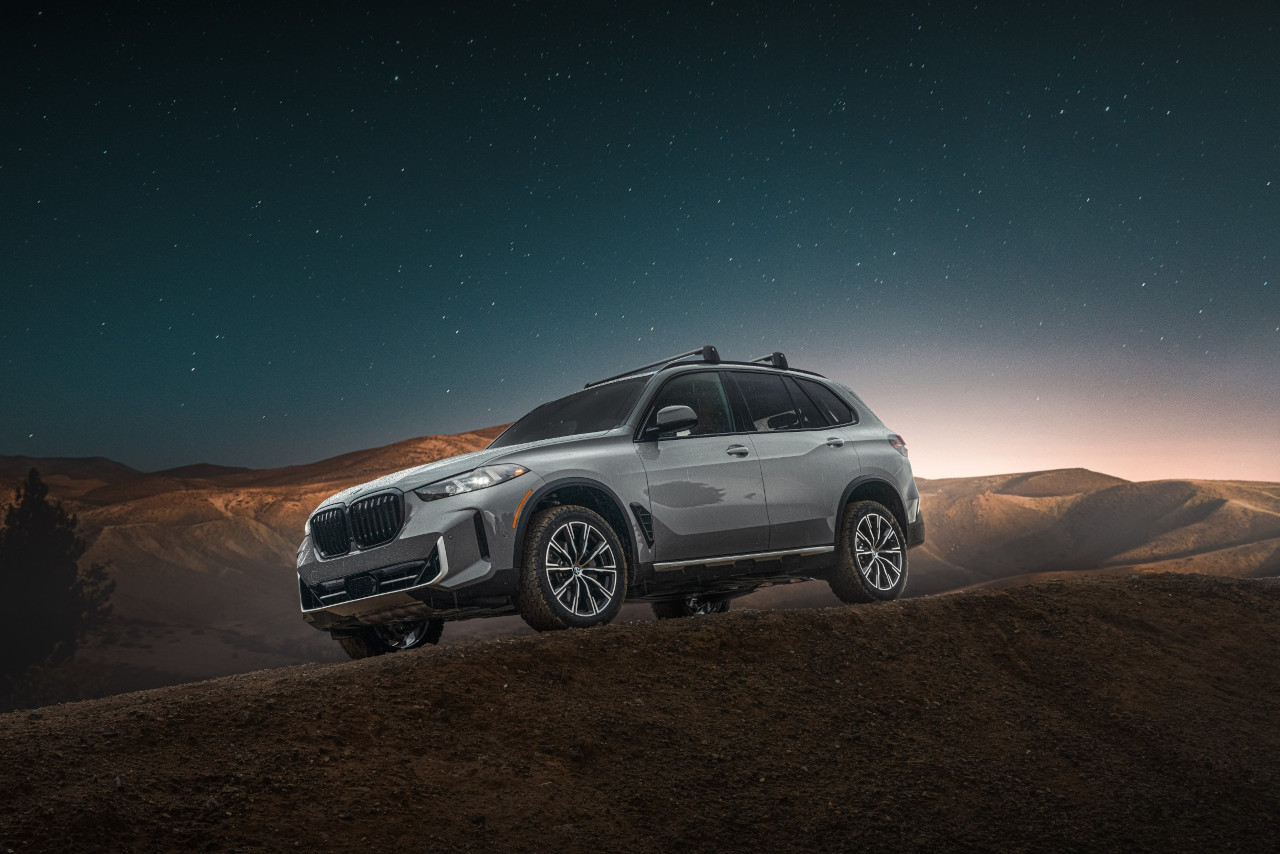 The BMW X5 Silver Anniversary Edition beauty shot on mountain terrain with a star filled sky. 
