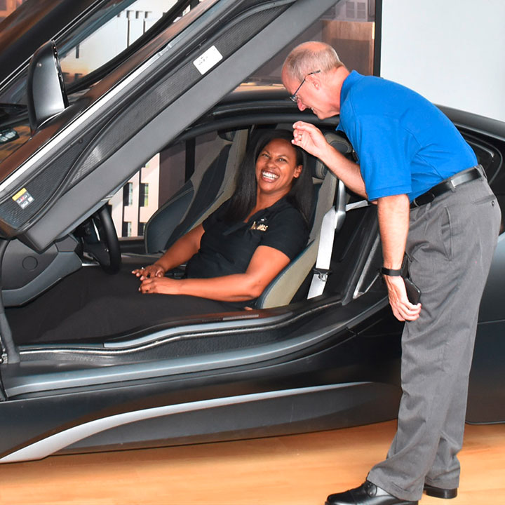 Teacher and student enjoy experiencing a BMW i8 on the platform in the Zentrum Museum.